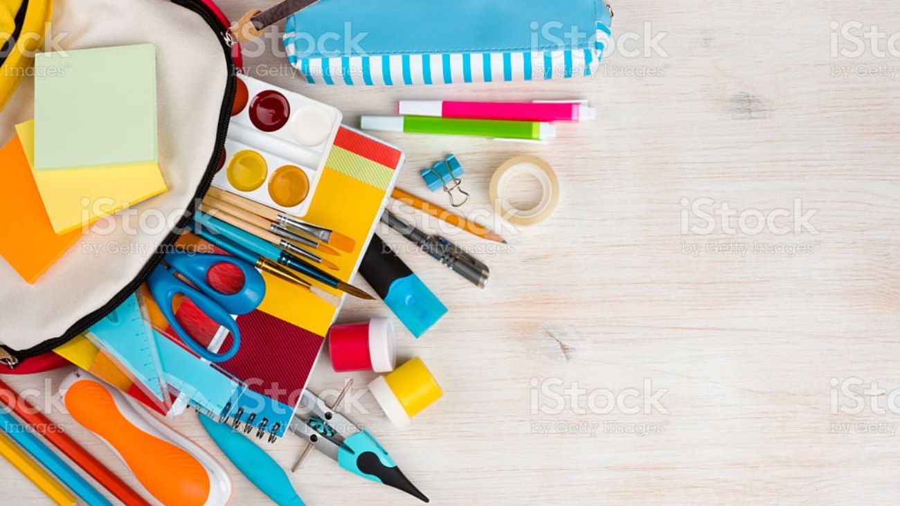 Various stationery school and office supplies over wooden texture background